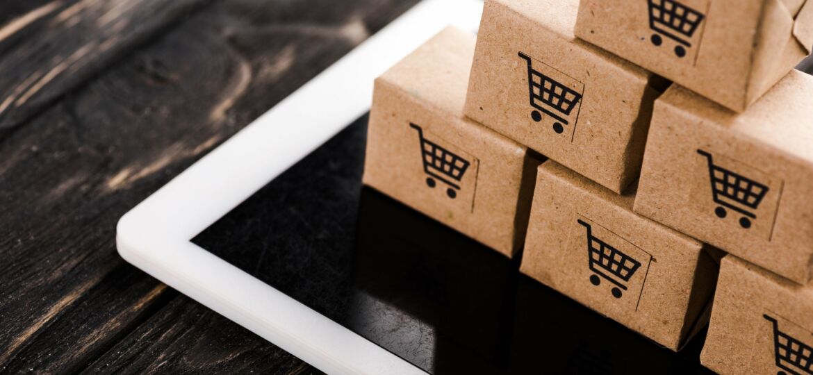selective focus of small carton boxes on digital tablet, e-commerce concept