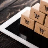 selective focus of small carton boxes on digital tablet, e-commerce concept